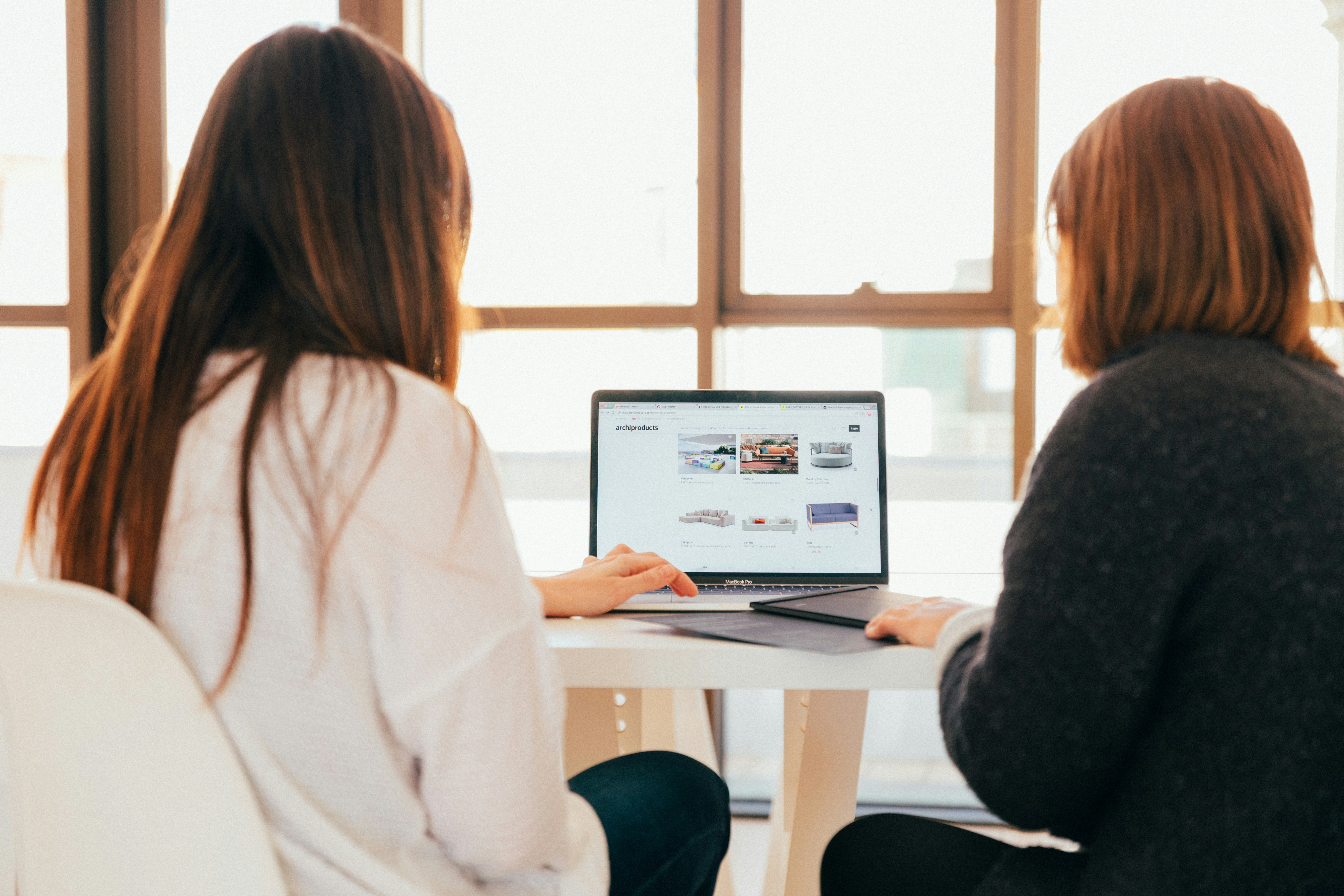 Two professionals collaborating on a laptop, representing teamwork and digital innovation